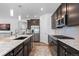 Bright kitchen with modern appliances, island seating, and dark wood cabinetry at 15802 Xanthia Way, Thornton, CO 80602
