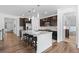 Spacious kitchen with dark cabinets, island seating, and hardwood floors at 15802 Xanthia Way, Thornton, CO 80602