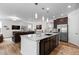 Modern kitchen with stainless steel appliances and a large center island open to the living room at 15802 Xanthia Way, Thornton, CO 80602