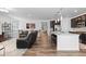 Open concept living room and kitchen with modern appliances and stylish decor and hardwood floors at 15802 Xanthia Way, Thornton, CO 80602