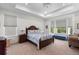 Bright main bedroom featuring a tray ceiling, bay windows and a plush king bed at 15802 Xanthia Way, Thornton, CO 80602