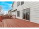The deck, made of stained wood, is attached to the home's white vinyl siding with sliding glass door access at 18948 E Baker Pl, Aurora, CO 80013