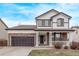 Charming two-story home featuring stone accents, a covered front porch, and a well-manicured lawn at 18948 E Baker Pl, Aurora, CO 80013
