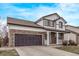 Inviting home with a two-car garage, stone accents, and a neatly kept lawn at 18948 E Baker Pl, Aurora, CO 80013