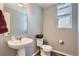 Powder room with pedestal sink, modern fixtures, and a window for natural light at 3075 Distant Rock Ave, Castle Rock, CO 80109