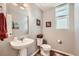 Powder bath features pedestal sink, wood floors, framed mirror, and neutral paint with decorative wall art at 3075 Distant Rock Ave, Castle Rock, CO 80109