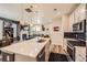 Modern kitchen features stainless appliances, large island with sink, and an open floor plan to the living area with fireplace at 3075 Distant Rock Ave, Castle Rock, CO 80109