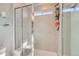Bathroom with sleek glass enclosed shower, light tile, and storage shelves with easy access from the shower at 3075 Distant Rock Ave, Castle Rock, CO 80109