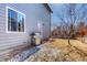 Backyard exterior showcasing a barbecue grill, door to the home, and partially snow-covered grass at 6462 Freeport Dr, Highlands Ranch, CO 80130