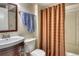 Traditional bathroom with a vanity, toilet, and shower behind a striped curtain at 6462 Freeport Dr, Highlands Ranch, CO 80130