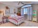 Bright bedroom featuring a quilt-covered bed, ceiling fan, and a large window letting in natural light at 6462 Freeport Dr, Highlands Ranch, CO 80130