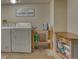 Well-lit laundry room equipped with a washer, dryer, and storage shelves at 6462 Freeport Dr, Highlands Ranch, CO 80130