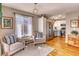 Bright living space with a view of the kitchen, hardwood floors, and a large sunny window at 6462 Freeport Dr, Highlands Ranch, CO 80130