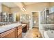A bathroom featuring double sinks, soaking tub, vanity, and tiled walk-in shower at 16399 Somerset Dr, Broomfield, CO 80023