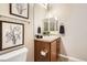 Bright bathroom with tiled shower, framed artwork, vanity with dark wood cabinets and black accessories at 16399 Somerset Dr, Broomfield, CO 80023