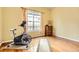 Bedroom with yellow walls, hardwood floors, exercise equipment, and natural light at 16399 Somerset Dr, Broomfield, CO 80023