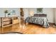 Bedroom showcasing hardwood floors, decorative bedside table, and adjacent bathroom entrance at 16399 Somerset Dr, Broomfield, CO 80023