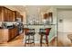Open kitchen with wood cabinets, granite counters, stainless steel appliances, and bar seating at 16399 Somerset Dr, Broomfield, CO 80023