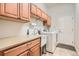 Bright laundry room boasts cabinets, sink, countertops and includes washer and dryer at 16399 Somerset Dr, Broomfield, CO 80023