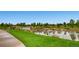 Scenic community pond with gentle waterfalls, bench, and lush green surroundings at 16399 Somerset Dr, Broomfield, CO 80023