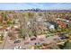 Aerial view of home in residential neighborhood with mature trees and downtown skyline at 2772 Julian St, Denver, CO 80211