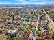 Expansive aerial view showcases a neighborhood with tree-lined streets and cityscape with mountain views in the distance at 2772 Julian St, Denver, CO 80211