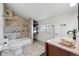 Bright bathroom featuring a tiled shower over tub, floating shelves and granite countertop at 2772 Julian St, Denver, CO 80211