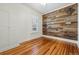 Bright bedroom boasts beautiful hardwood floors, custom wood accent wall, and a large window for natural light at 2772 Julian St, Denver, CO 80211