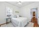This bedroom features a bed with white comforter and accent pillows, a ceiling fan, and hardwood flooring at 2772 Julian St, Denver, CO 80211