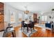 A beautifully designed dining area features wood floors, a stylish rug, and a charming brick fireplace at 2772 Julian St, Denver, CO 80211
