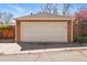 Detached two-car garage with an off-white door and sconce lighting, conveniently situated in the backyard at 2772 Julian St, Denver, CO 80211