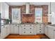 This modern kitchen features white cabinetry, sleek countertops, and a stylish range hood over the cooktop at 2772 Julian St, Denver, CO 80211