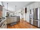 The kitchen featuring stainless steel appliances, granite counters, adjacent rooms, and wood floors at 2772 Julian St, Denver, CO 80211