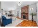 Cozy living room with a brick fireplace, hardwood floors, and an open layout leading to the dining area at 2772 Julian St, Denver, CO 80211