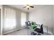 Sunlit bedroom with two windows, neutral carpeting, ceiling fan, and equipped with an office desk at 3885 Sandoval St, Brighton, CO 80601
