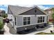 Side view of the house featuring gray siding, stone accents, and a backyard patio at 3885 Sandoval St, Brighton, CO 80601