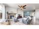 Bright living room with a stone fireplace, ceiling fan, hardwood floors, and comfortable seating at 3885 Sandoval St, Brighton, CO 80601