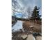 Large backyard featuring a retaining wall, trees and a wooden fence at 21041 E Ida Ave, Centennial, CO 80015