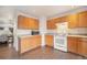 Functional kitchen featuring wood cabinets, hard surface countertops, and hardwood floors at 6052 Jay St, Arvada, CO 80003