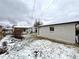 Backyard view of home featuring a detached garage, partial snow cover and a brick exterior at 3578 Ivanhoe St, Denver, CO 80207