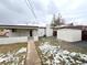 Backyard view of home featuring a shed, partial snow cover and a brick exterior at 3578 Ivanhoe St, Denver, CO 80207