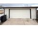 A detached one car garage with white panel door and brick exterior at 3578 Ivanhoe St, Denver, CO 80207