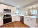 Modern kitchen with stainless appliances, white cabinets, quartz countertop and hardwood floors at 3578 Ivanhoe St, Denver, CO 80207