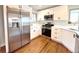 Beautiful kitchen featuring stainless steel appliances, modern white cabinets, and hardwood floors at 3578 Ivanhoe St, Denver, CO 80207