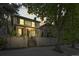 Charming home exterior with decorative wrought iron fence, mature trees, and classic architecture at dusk at 734 N Downing St, Denver, CO 80218