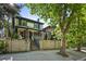 Two-story home with black trim, complemented by a mature tree, fence, and a charming entrance at 734 N Downing St, Denver, CO 80218