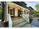 Charming front porch with a white railing, dark trim, seating, and a hanging lantern at 734 N Downing St, Denver, CO 80218