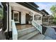 Charming front porch with dark exterior paint, white columns, wood floors, and stylish overhead lighting at 734 N Downing St, Denver, CO 80218