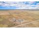 Expansive aerial view showing the property and surrounding farmlands under a partly cloudy sky at 1222 S County Road 185, Byers, CO 80103