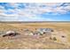 Aerial view of the house and buildings surrounded by farm land under a blue and cloudy sky at 1222 S County Road 185, Byers, CO 80103